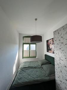 施特拉尔松德Traumwohnung am Altstadt Hafen Stralsund的一间卧室设有一张绿色的床和一个窗户。