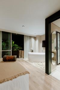 麦德林1616 Hotel Medellin的一间带大床和浴缸的浴室