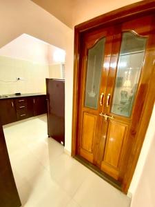 班加罗尔Art House- Air conditioned luxury service Apartments的厨房设有木门和冰箱。
