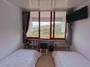 CampakaDe Pointé Resort & Resto的一间卧室设有两张床和大窗户
