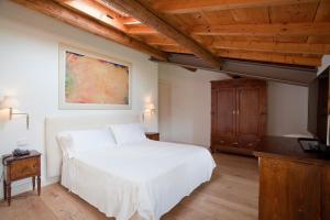 索纳Relais Corte Guastalla Apartments的卧室设有白色的床和木制天花板。