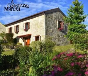 蒙达里斯A Cantaruxa Maruxa Turismo Rural的一座石头房子,前面设有花园