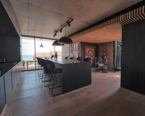 卡诺海滩Villa Ananda 5 étoiles de rêves的一个带桌椅和海滩的厨房