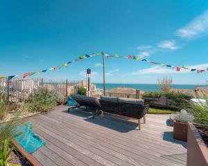 卡诺海滩Villa Ananda 5 étoiles de rêves的木甲板上设有长凳和船只