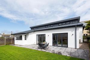 廷塔杰尔The Hideaway, Modern 3 bed in Tintagel, Cornwall的白色的房子,设有黑色的屋顶和庭院