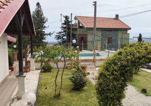 马斯卡利Peri Peri Guest House的一座带游泳池的房屋和一座树木繁茂的庭院