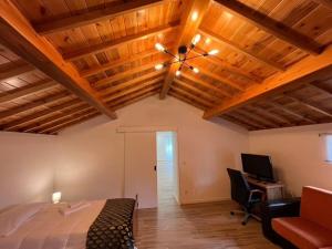 AgualvaCasa do Avô Fernando的一间带木制天花板、一张床和一张书桌的卧室