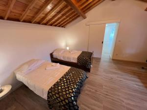 AgualvaCasa do Avô Fernando的客房铺有木地板,配有两张床。