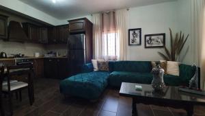 AlaminosOikos Selinolithos的客厅配有绿色沙发和桌子