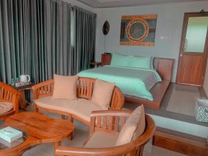 CampakaDe Pointé Resort & Resto的卧室配有一张床和一张桌子及椅子