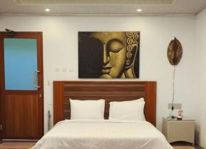 CampakaDe Pointé Resort & Resto的卧室配有一张床,墙上挂有绘画作品