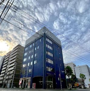 札幌WISE OWL HOSTELS SAPPORO的城市街道上一座蓝色的大建筑