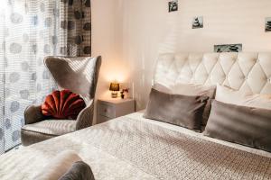 阿莫迪Villa Corali Apartments Sea Breath & Pool的一间卧室配有一张床、一把椅子和一张小床。