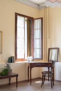 法拉-迪索利戈Fiori&vigne di Cecilia Marcon的客房设有木桌和2扇窗户。