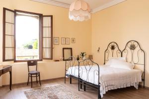 法拉-迪索利戈Fiori&vigne di Cecilia Marcon的一间卧室配有一张床、一张书桌和一个窗户。