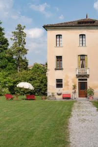 法拉-迪索利戈Fiori&vigne di Cecilia Marcon的院子内带长椅和遮阳伞的大型建筑