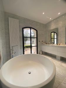 马莱莫尔chambre d'hôte sur le golf de pont royal的浴室内设有大型白色浴缸。