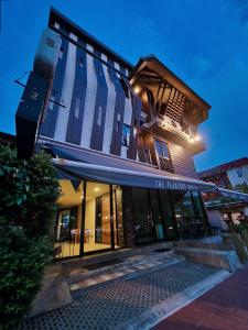 清迈The Peaberry Boutique Hotel的一座高大的建筑,上面有蓝色遮阳篷