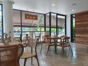 清迈The Peaberry Boutique Hotel的用餐室设有桌椅和窗户。
