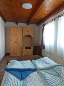 KővágóörsOrbán nyaralóház的一间卧室设有一张带木制天花板的大床