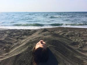 乌雷基HOTEL - SHORENA的躺在沙滩上的女人