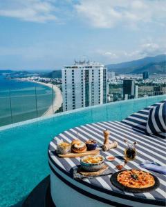 芽庄OceanDream Panorama Luxury Suites的水边建筑物顶部的餐桌
