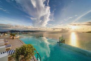 芽庄OceanDream Panorama Luxury Suites的水边的大型游泳池