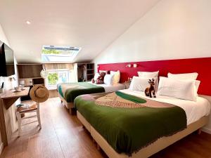 韦尔东河畔拉帕吕Hotel Le Provence - Restaurant Le Styx的卧室内的两张床,配有红色和绿色床单