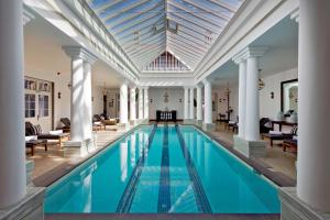 努沃勒埃利耶The Grand Hotel - Heritage Grand的一个带柱子和天花板的室内游泳池