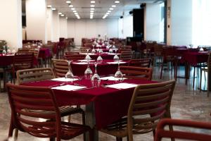 佩尼斯科拉阿哥拉Spa度假酒店的用餐室配有红色桌椅和酒杯