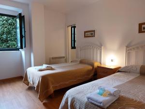 萨莫斯Hospedería Externa del Monasterio的一间卧室设有两张床和窗户。