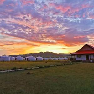 HujirtTalbiun Lodge的一片落日,一片田野上一群白色帐篷
