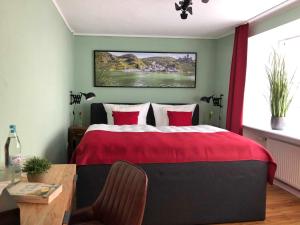 埃迪格尔-埃莱尔Ferienhaus-Am-Alten-Stadttor的一间卧室配有一张红色棉被的床