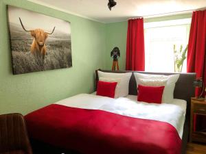 埃迪格尔-埃莱尔Ferienhaus-Am-Alten-Stadttor的卧室配有红色和白色的床,并画着一只公牛