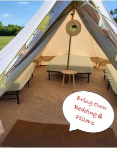 Corfe MullenDorset Glamping Fields的帐篷,配有椅子和只放出枕头的标志