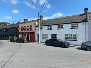 KilcullenRooms At Mcternans的一条街道,两辆车停在白色建筑前面