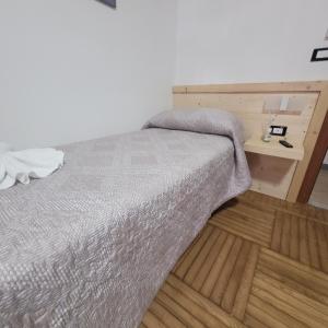 维纳迪奥蒙特尼比尔斯小屋酒店的一间卧室配有一张床,铺有木地板