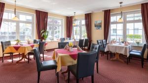 华法林安瓦里纳希酒店的用餐室设有桌椅和窗户。
