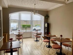 利文-法夫Lomond Guest House的餐厅设有桌椅和窗户。