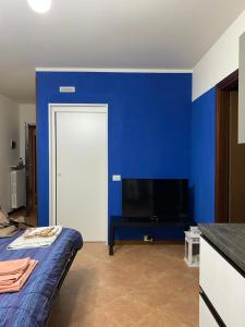 RonchiA casa di Laura with pool and free bikes的蓝色的房间,配有床和电视