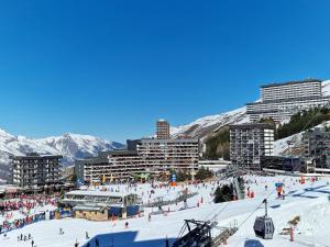 里蒙纽耶Studio au coeur de la station des Menuires的一群人,在雪地的滑雪场