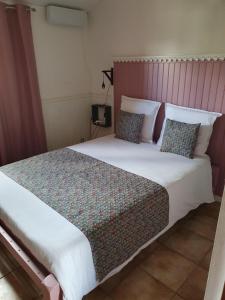 卡夫尔高原Chambres et Table d'hôte Les Hortensias的一间卧室配有一张带枕头的大床