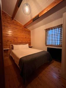 桑提亚纳德玛Villas Vairocana的卧室配有一张床铺,位于带木墙的房间内