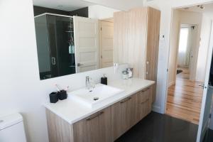 魁北克市Le Citadin - Maison neuve moderne & ensoleillée的浴室设有白色水槽和镜子