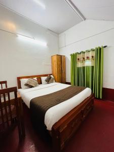马迪凯里Coorg Daffodil Guesthouse的一间卧室配有一张带绿色窗帘的大床