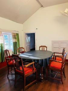 马迪凯里Coorg Daffodil Guesthouse的一间用餐室,配有黑色的桌子和椅子