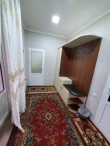 撒马尔罕Nursultan Grand Guest House的空房间,有书桌和地毯