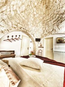洛科罗通多特鲁利卡罗酒店的一间卧室设有一张带石墙的大床