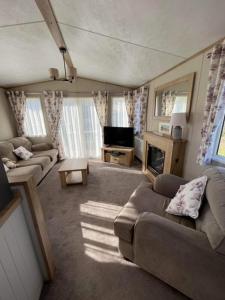 古德瑞同3 bed luxury lodge at Hoburne Devon Bay的带沙发和电视的大型客厅
