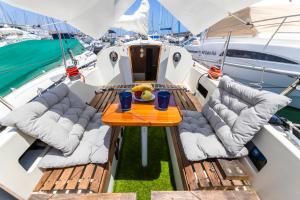 卡列罗港Seaside Chill-out Stay on a Sail Yacht的码头上船上的桌椅